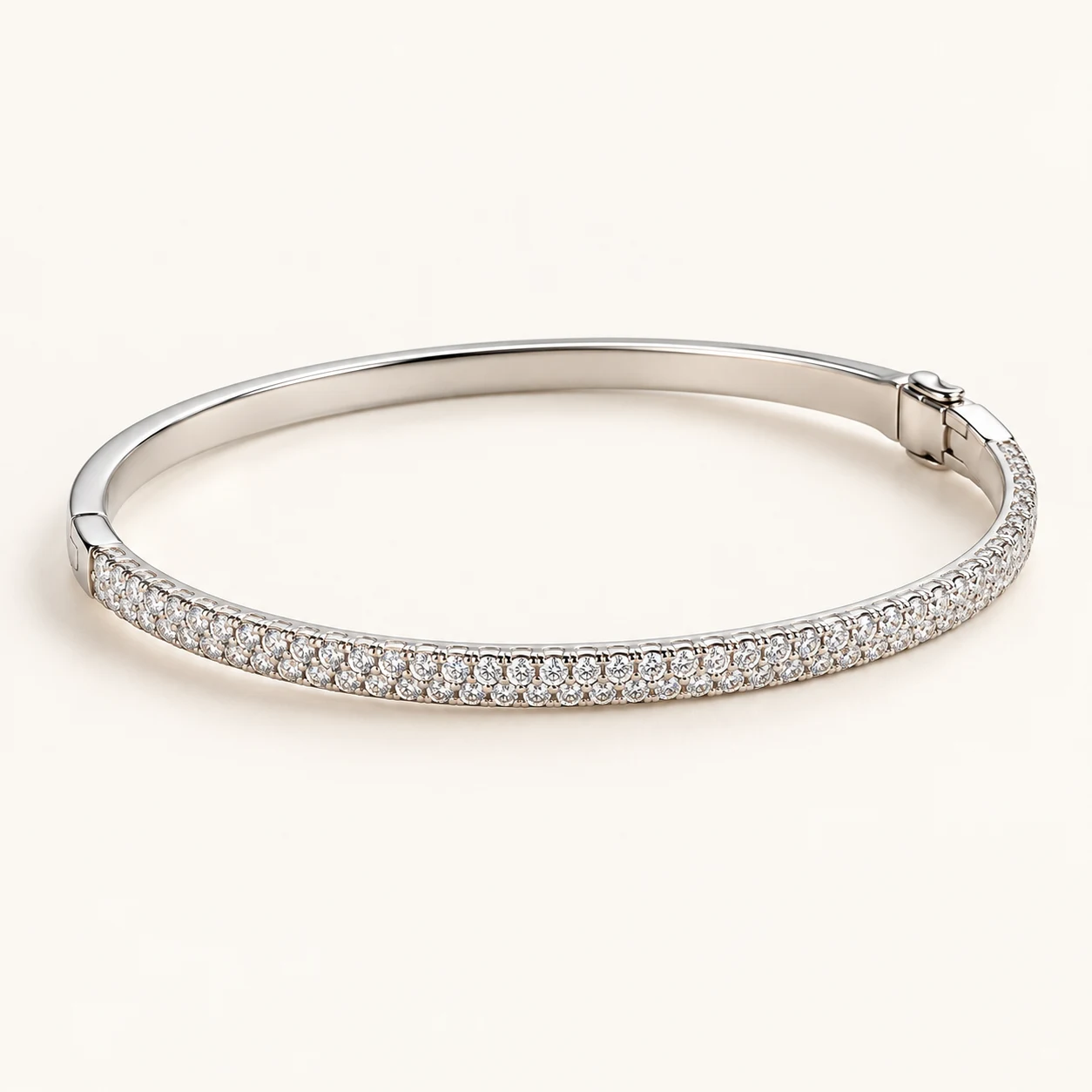 Élan Pavé in Silver, slim hinged oval rigid bangle, front half narrow band with closely pave set small round clear cubic zirconia, back half plain metal